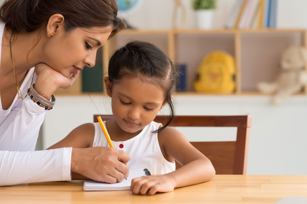 Adult helping young girl with homework