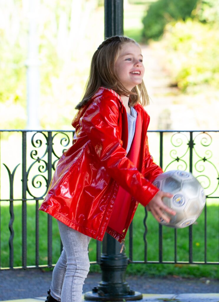Smiling girl catching a football