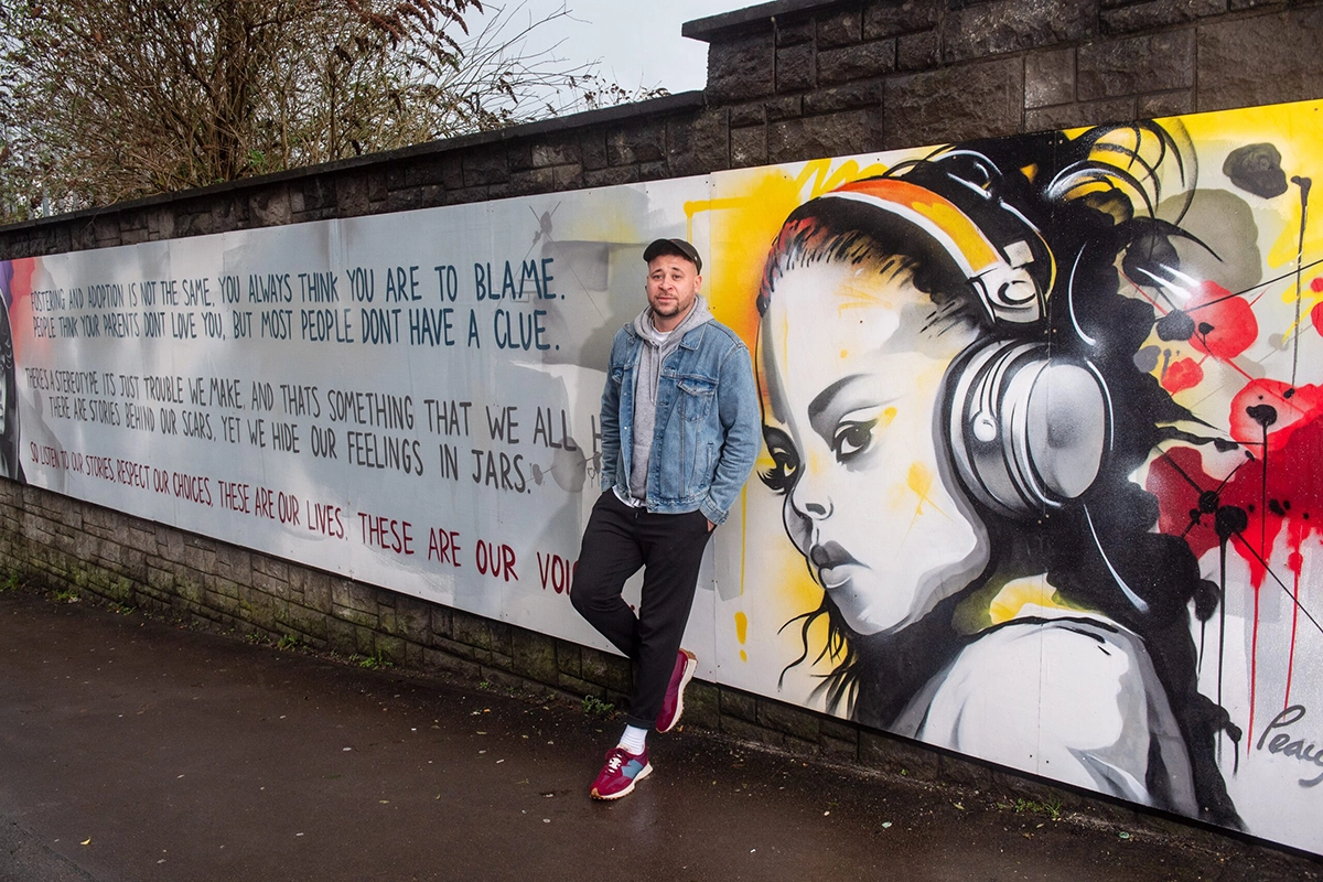 Connor Allen leaning against mural wall