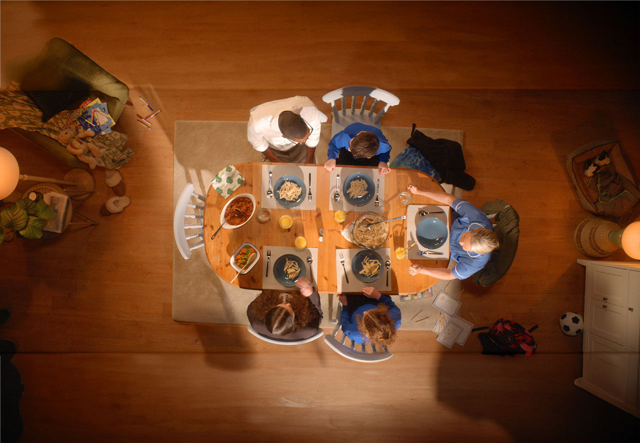 Family sat at a dining table eating dinner