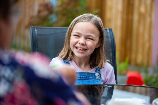 Young girl wearing dungarees laughing