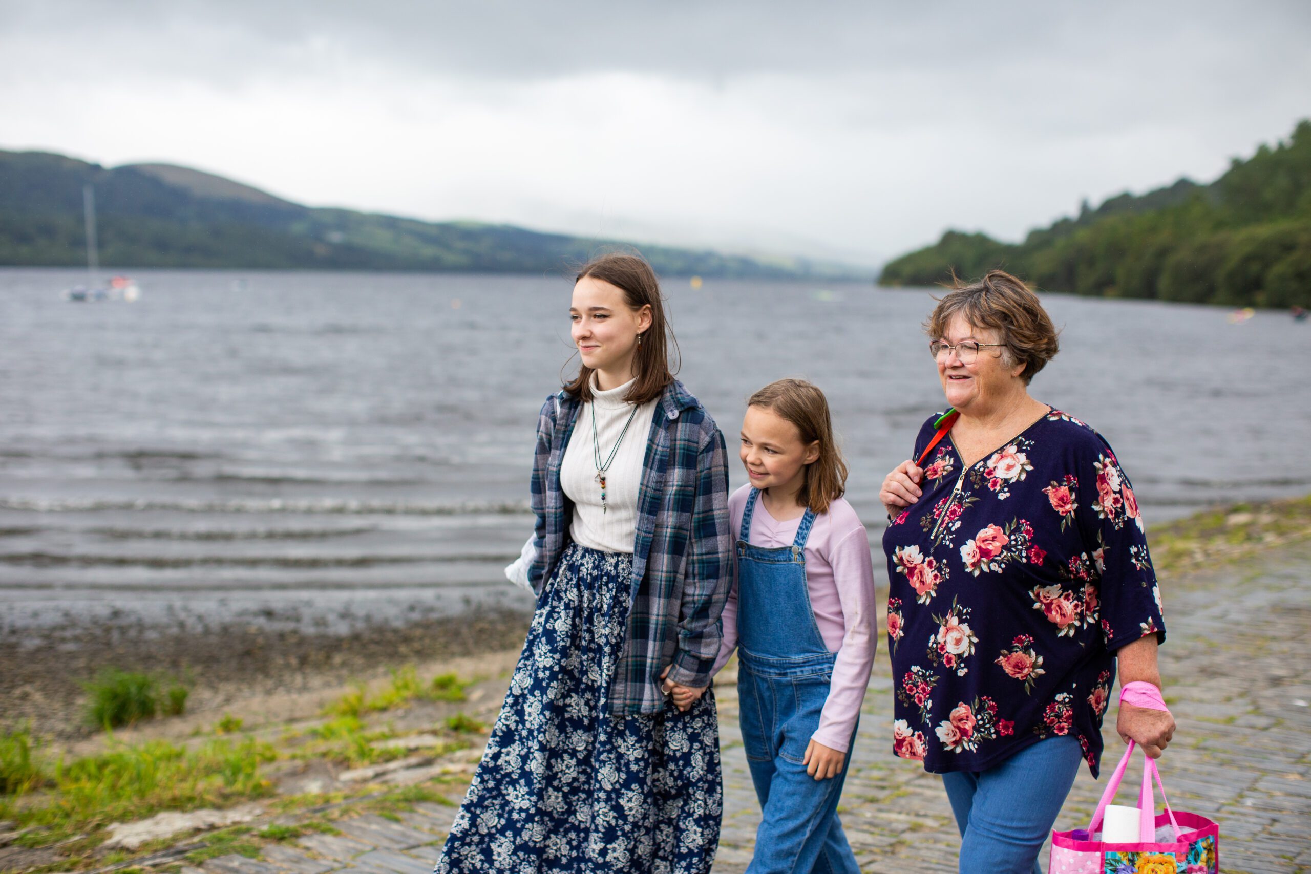 Lady and two girls walking by a lake in Wales